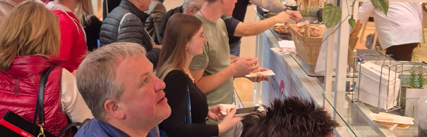 Fachbesucher erleben FitKitchen® live am Welbilt Messestand auf der „Alles für den Gast“ 2025 in Salzburg – Verkostung und Interaktion am offenen Showküchen-Counter.